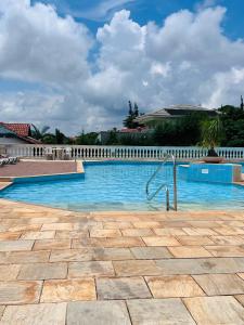 a swimming pool with blue water and a white fence at Flat Piemonte Apart in Serra Negra