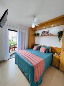 a bedroom with a bed with blue sheets and a window at Flat Piemonte Apart in Serra Negra
