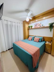 a bedroom with a blue bed with a ceiling fan at Flat Piemonte Apart in Serra Negra +37 photos
