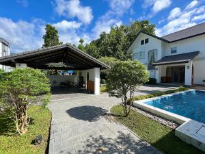 a house with a swimming pool in the yard at LKM Pool Villa in Chiang Mai