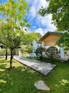 a walkway in front of a house with a tree at LKM Pool Villa in Chiang Mai