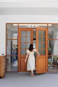 a woman in a white dress walking into a door at LKM Pool Villa in Chiang Mai +70 photos