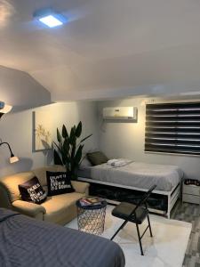 a living room with two beds and a couch at Gray Room The White Haven In Clark in Angeles