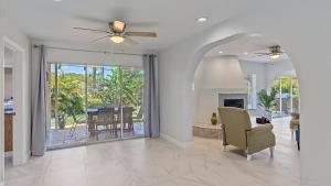 a living room with a ceiling fan and a fireplace at Paradise Palace in Sarasota