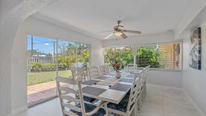 a dining room with a table and chairs and a ceiling fan at Paradise Palace in Sarasota