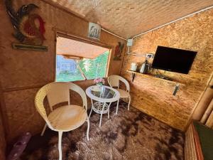 a small room with a table and chairs and a tv at ข้าวทุ่งเบ็ญจาโฮมสเตย์ in Ban Hat Phang