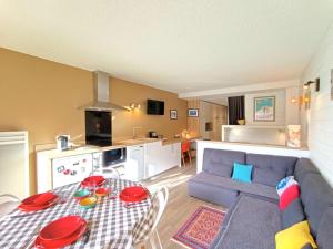 a living room with a table and a blue couch at Studio cosy pour 4 pers. à Saint-Lary-Soulan, balcon, parking, lave-linge - FR-1-457-364 in Saint-Lary-Soulan