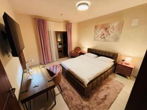 a bedroom with a bed and a desk and a television at Mellis Boutique in Cluj-Napoca
