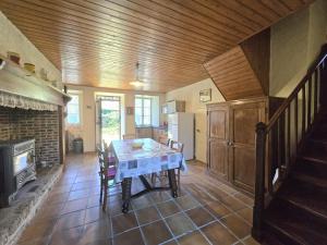 Un comedor con mesa y chimenea. en Maison périgourdine familiale proche sites préhistoriques - FR-1-616-291, en Grèzes