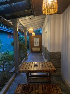 a patio with a wooden table and a chandelier at Thisu Villa in Dickwella