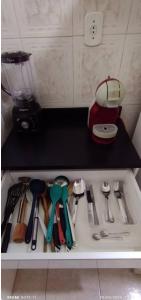 a drawer with a bunch of utensils on a shelf at Amplo Apartamento in Rio de Janeiro