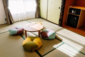 a room with four colorful chairs and a table at Smooth & Living in Ueda +3 photos