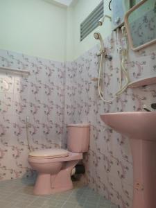 a bathroom with a pink toilet and a sink at Travellers Home in Matara