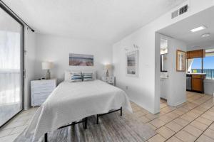 ein weißes Schlafzimmer mit einem Bett und einem großen Fenster in der Unterkunft Gulf Shores Surf & Racquet 716A in Gulf Shores + 38 Fotos