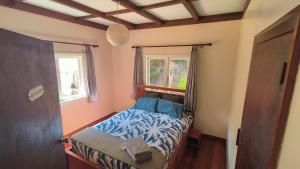 a small bedroom with a bed with a window at Wainui bush retreat in Kaeo