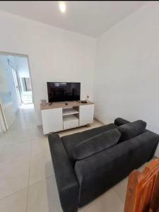 a living room with a black couch and a tv at Complejo Virgen de Guadalupe in La Rioja