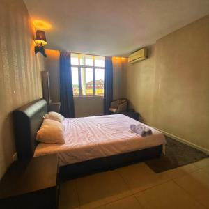 a small bedroom with a bed and a window at Ipoh Apartment Suites in Ipoh