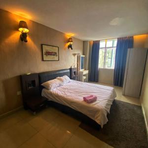 a bedroom with a bed with a pink bag on it at Ipoh Apartment Suites in Ipoh