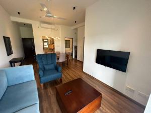 a living room with a couch and a tv on a wall at Luxury Golf and Relaxation in Gonapola