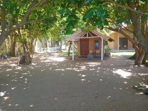 ゴールにあるSuha Beach Double Cabanaの木々のある庭の真ん中にある小さな建物