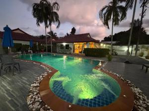 a swimming pool at night with a house in the background at MATA Garden resort Ao Nang in Ao Nang Beach
