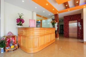 a wooden counter in a lobby with flowers on it at Khách Sạn Bình An in Sóc Sơn