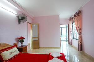 a living room with a red bed and a hallway at Khách Sạn Bình An in Sóc Sơn
