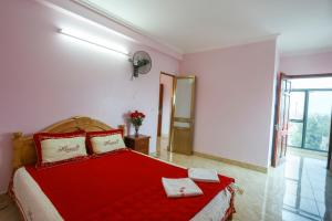 a bedroom with a red bed with a red blanket at Khách Sạn Bình An in Sóc Sơn