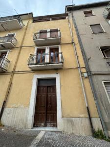 a building with a door and two balconies on it at Il Rifugio in Piazza in Castel di Sangro