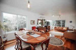 a dining room with a table and a living room at Craypot Cottage in Port Campbell