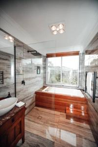 a bathroom with a tub and a sink and a shower at Craypot Cottage in Port Campbell +21 photos