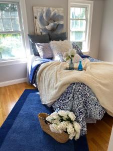 une chambre avec un lit avec des fleurs dessus dans l'établissement COZY, MODERN, Charming Cottage 1min to the beach, à Quincy