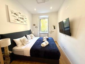 a bedroom with a bed with pillows and a television at Boutique Apartment Trieste in Trieste