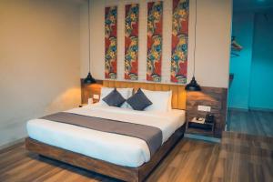 a bedroom with a bed and a painting on the wall at Jade City Hotel in Pokhara