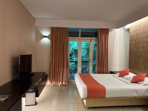 a bedroom with a bed and a desk and a window at Foy's Lake Resort in Chittagong