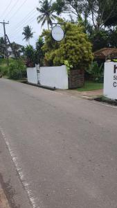 a street with a sign on the side of a road at Madiha Sampath Surf Villa in Matara