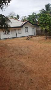 a white house with a yard in front of it at Madiha Sampath Surf Villa in Matara