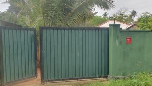 a green fence with a red box on top of it at Madiha Sampath Surf Villa in Matara