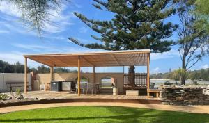 a wooden gazebo with a deck in a yard at Archy's on the Lake in Burrill Lake