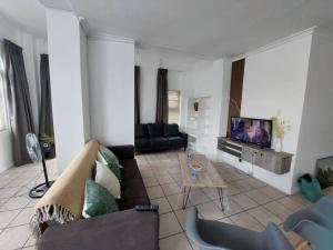 a living room with a couch and a tv at Azzure Apartments 4 sleeper Strand in Strand