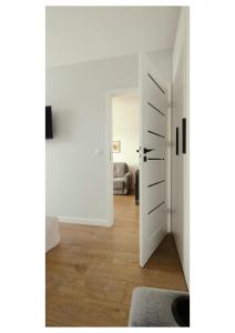 a hallway with a door leading to a living room at Apartament Blask, w zaciszu zieleni z ogródkiem in Bydgoszcz