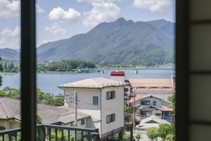 ein Blick aus einem Fenster auf eine Stadt mit einem Berg in der Unterkunft LakeView-Rental Villa Engawa House in Fujikawaguchiko