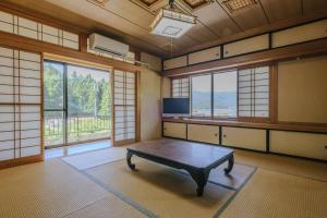 Zimmer mit einem Tisch in einem Zimmer mit Fenstern in der Unterkunft LakeView-Rental Villa Engawa House in Fujikawaguchiko