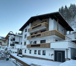 budynek z śniegiem na ziemi przed nim w obiekcie Chalet Sofie w mieście Ischgl