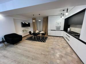 a kitchen and living room with a table and chairs at Sofia TS apartment in Craiova