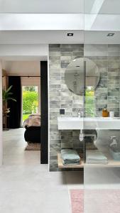 a bathroom with a sink and a mirror at Slapen bij de Zeeuwse Lala in IJzendijke