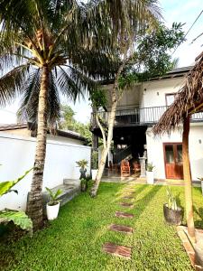 a backyard with palm trees and a house at Surf Heavens in Dickwella