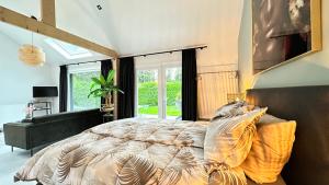 a bedroom with a bed and a large window at Slapen bij de Zeeuwse Lala in IJzendijke