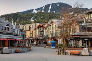 a street in a town with buildings and a mountain at Creekside Oasis 4 Beds Pool and Hot Tub in Whistler