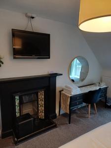 a living room with a fireplace and a tv on the wall at Jacobite Rose in Inverness